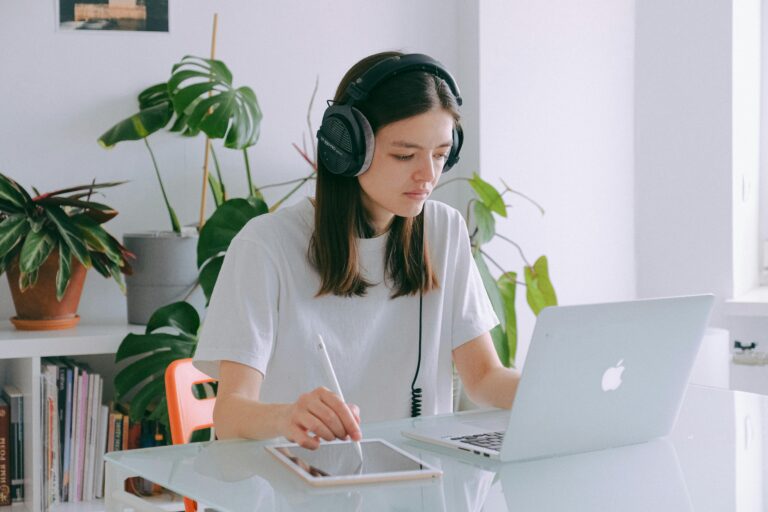 A professional adult student using a headset and tablet for an online English class.