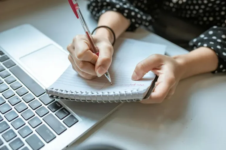 Close-up of a student taking notes during an English exam preparation session.